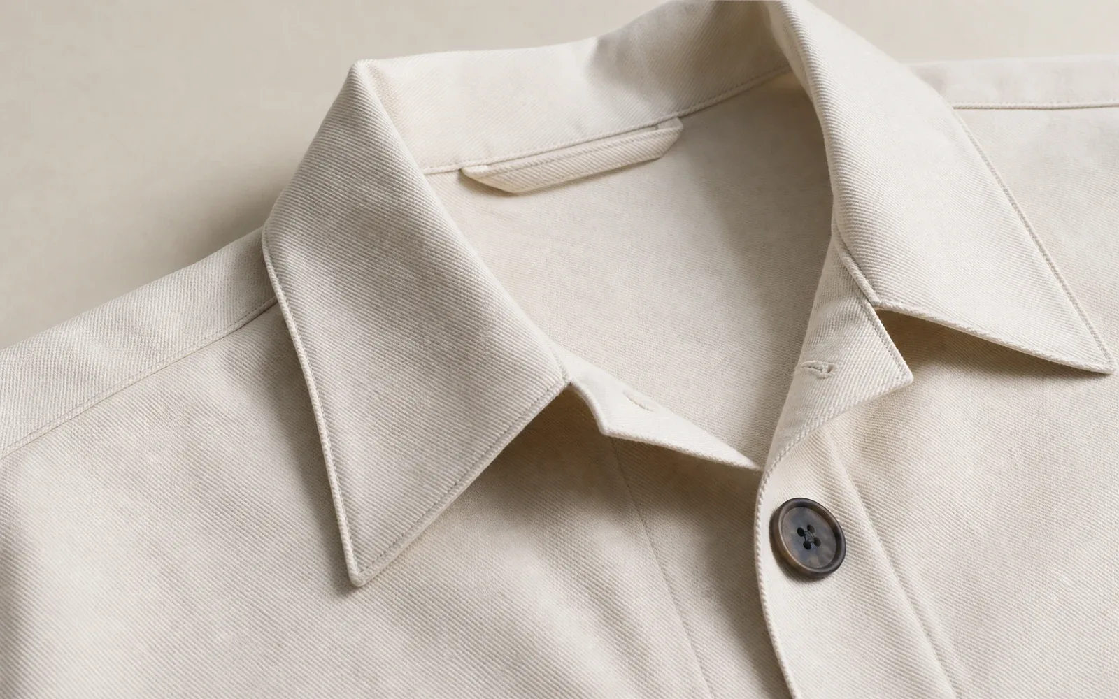 Close-up of an ivory custom garment collar and button detail