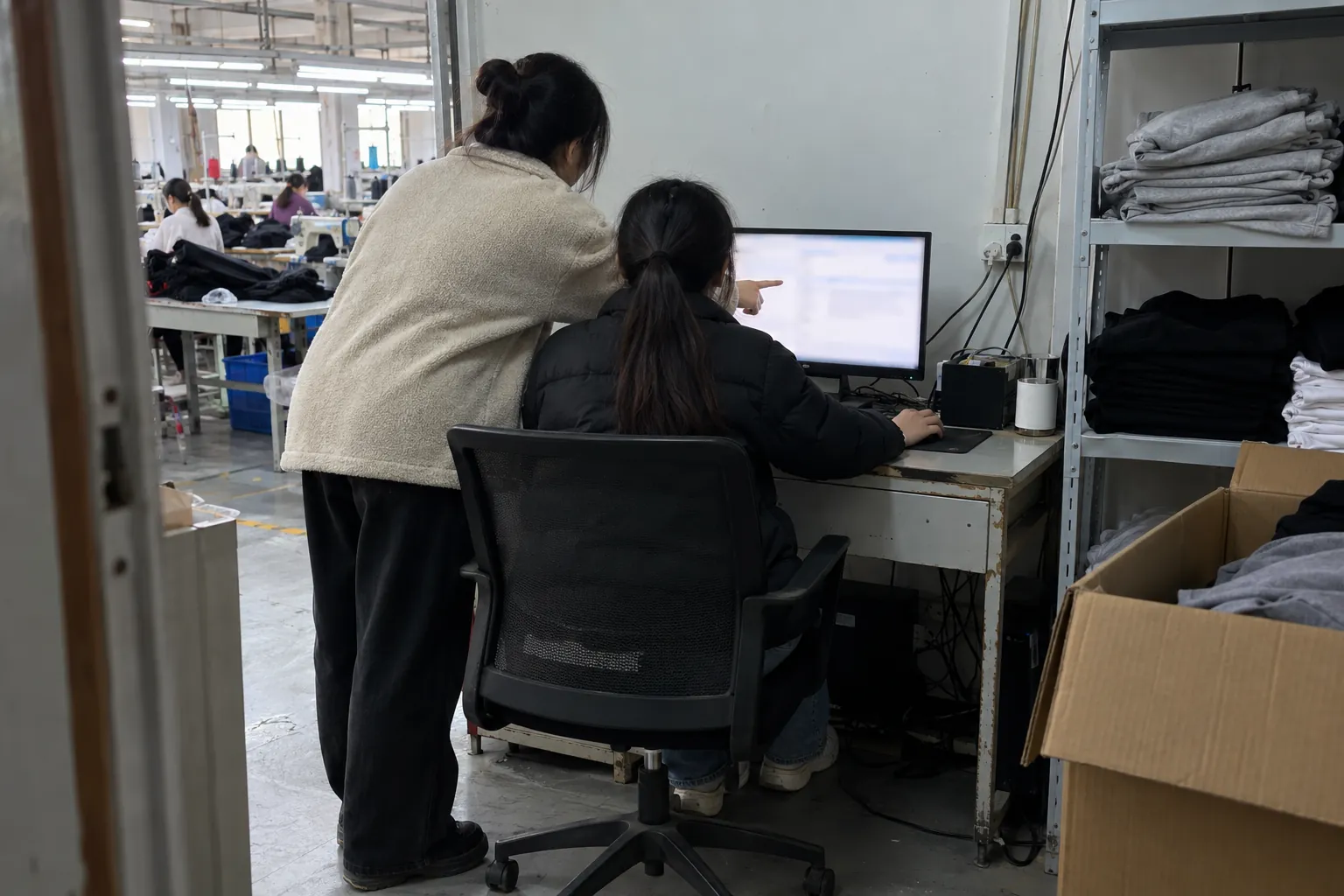 Dos personas revisando un ordenador en una pequeña oficina de expediciones.